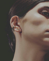 Close-up of a person wearing earrings with a dark background