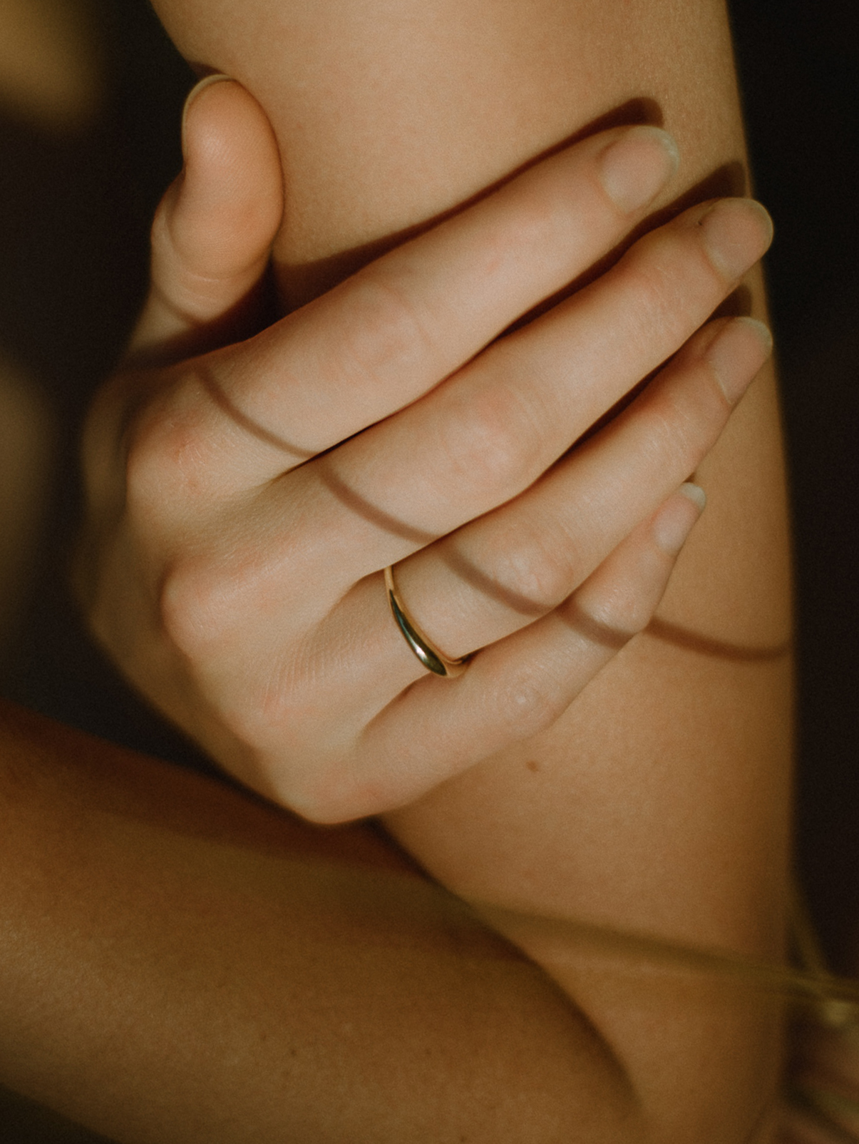 Close up of fine gold band ring on hand