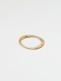 A single gold ring with an irregular band design, displayed against a white background.