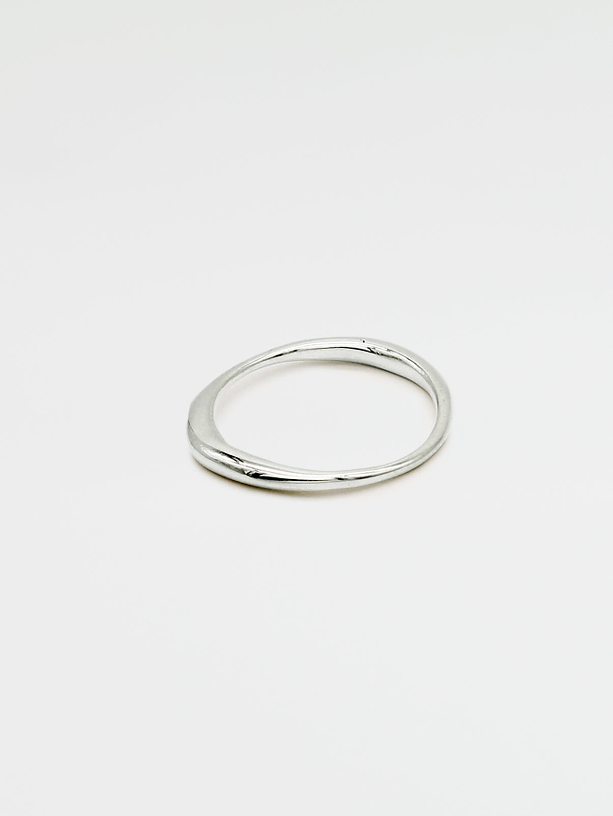 A single silver ring with an irregular band design, displayed against a white background.