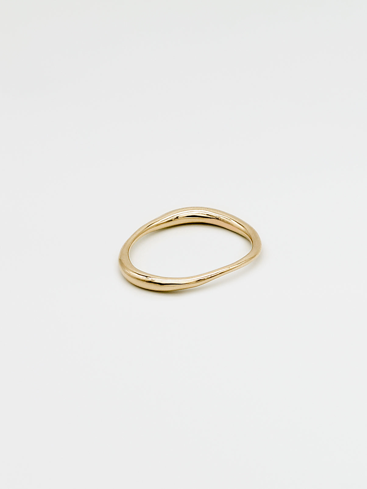 Irregular, organic, fine gold band on white background