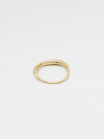 A fine gold ring with a carved, irregular design, displayed on a plain white background.