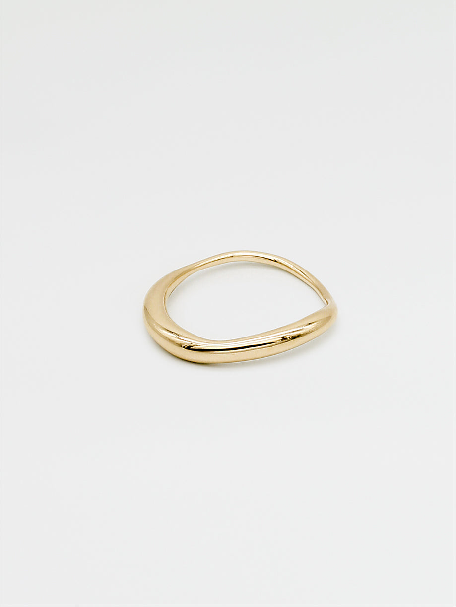 A fine gold ring with a carved, irregular design, displayed on a plain white background.