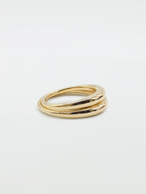 Two bulbous gold rings stacked on top of each other on white background