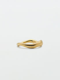 A gold band ring with a carved, irregular design on a plain white background.
