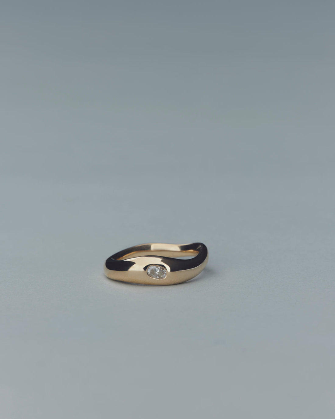 Gold ring with a diamond on a gray background