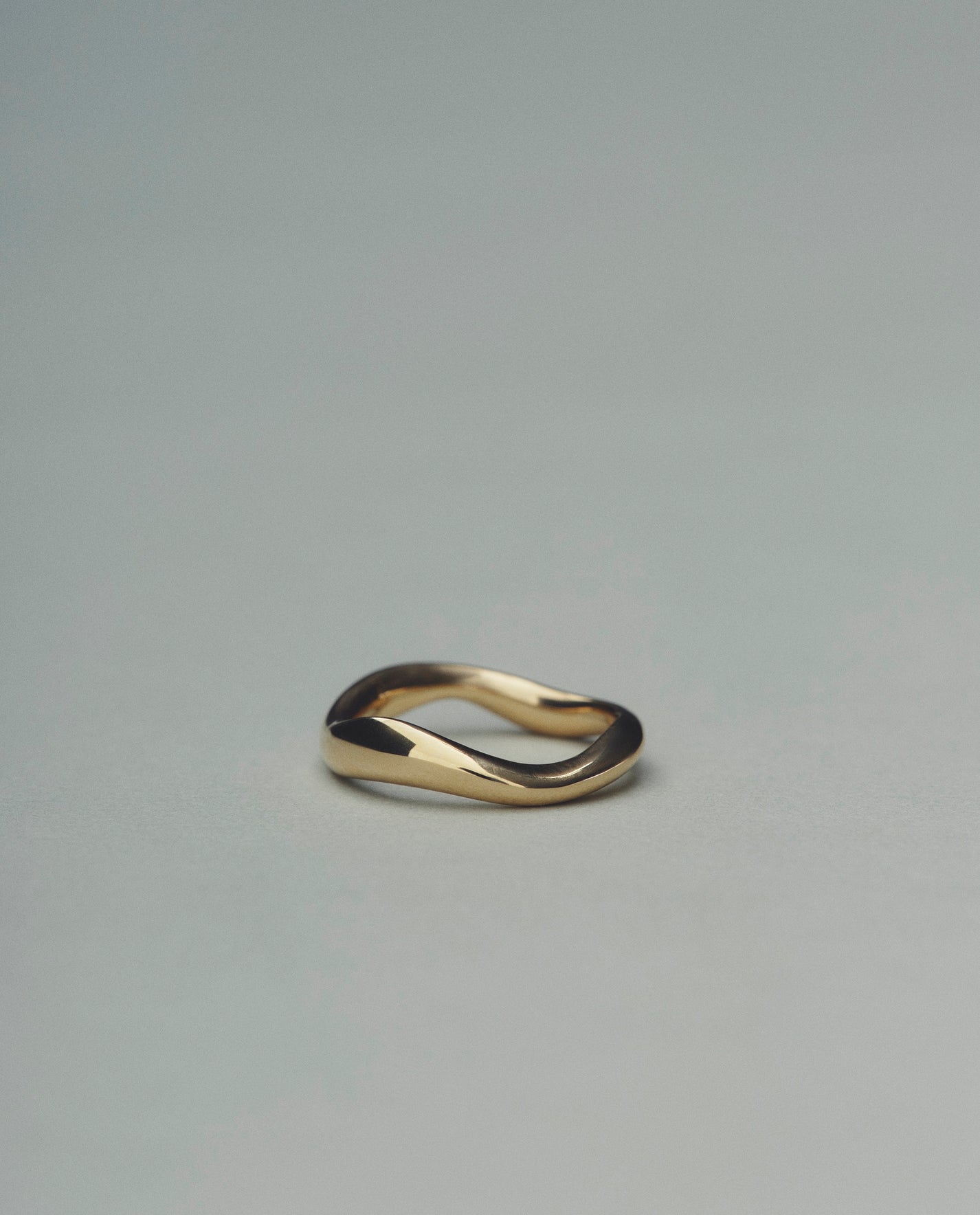 Gold ring with a unique design on a gray background