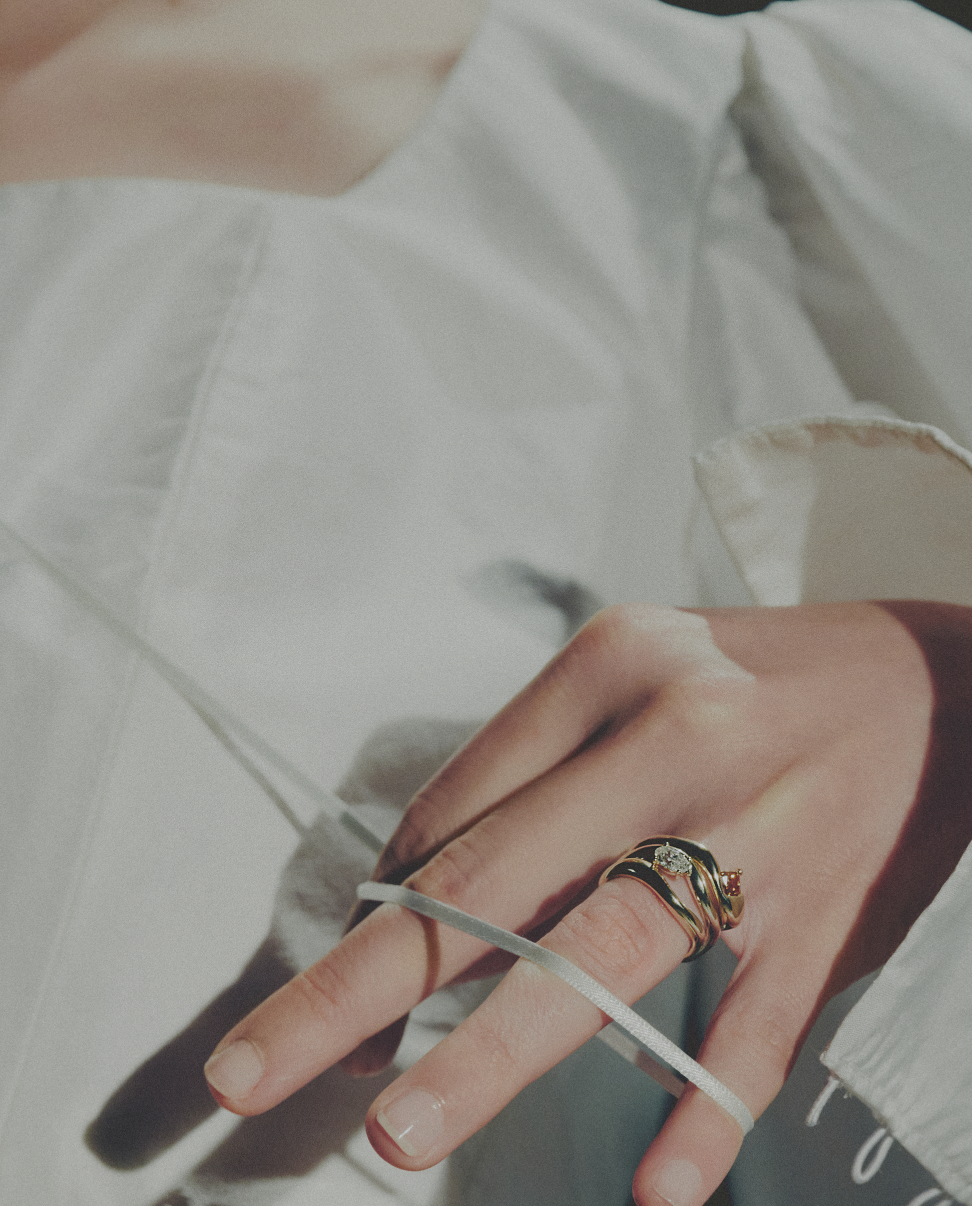 Close-up of a hand wearing gold rings with a blurred background