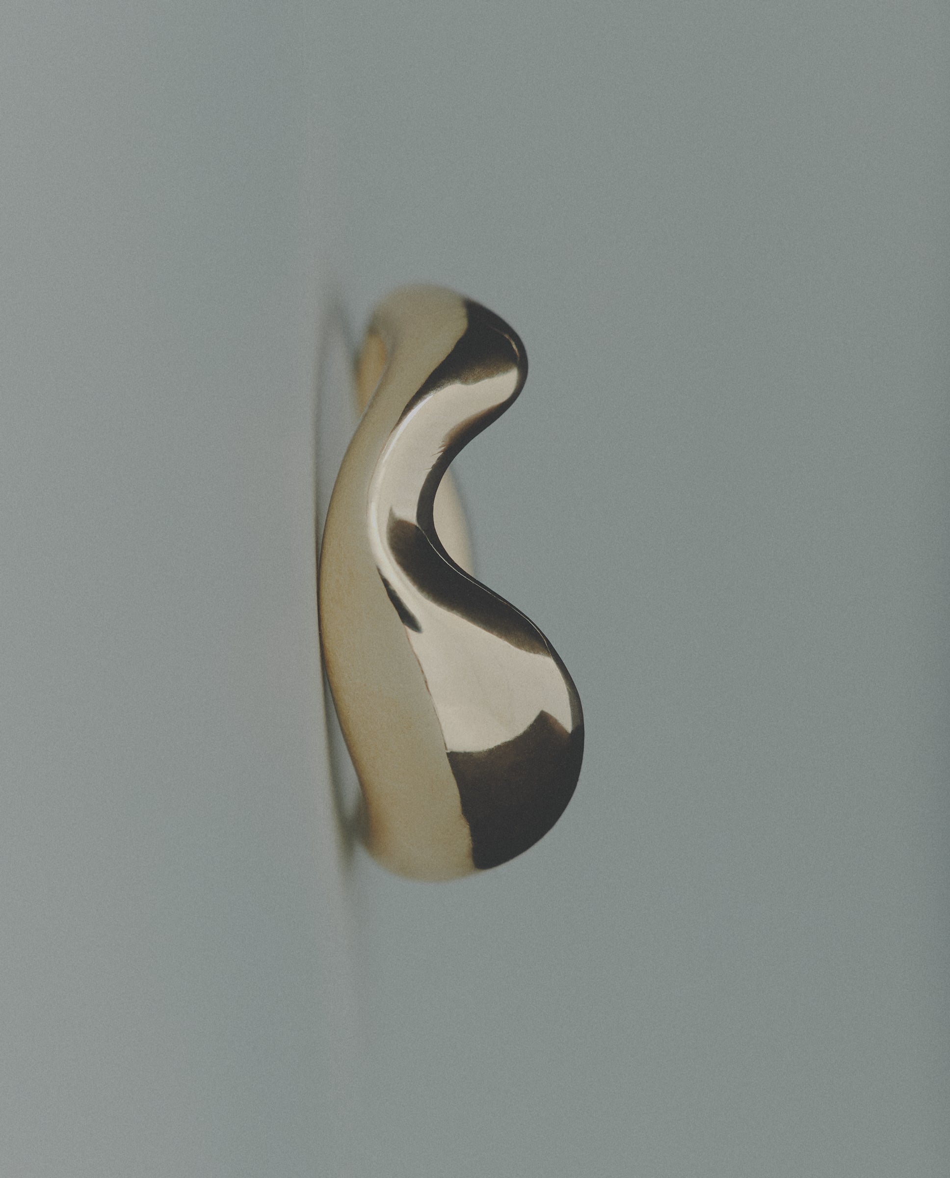Wavy bold gold ring on gray background