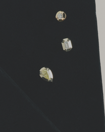 Close-up of three diamond earring studs on a black background
