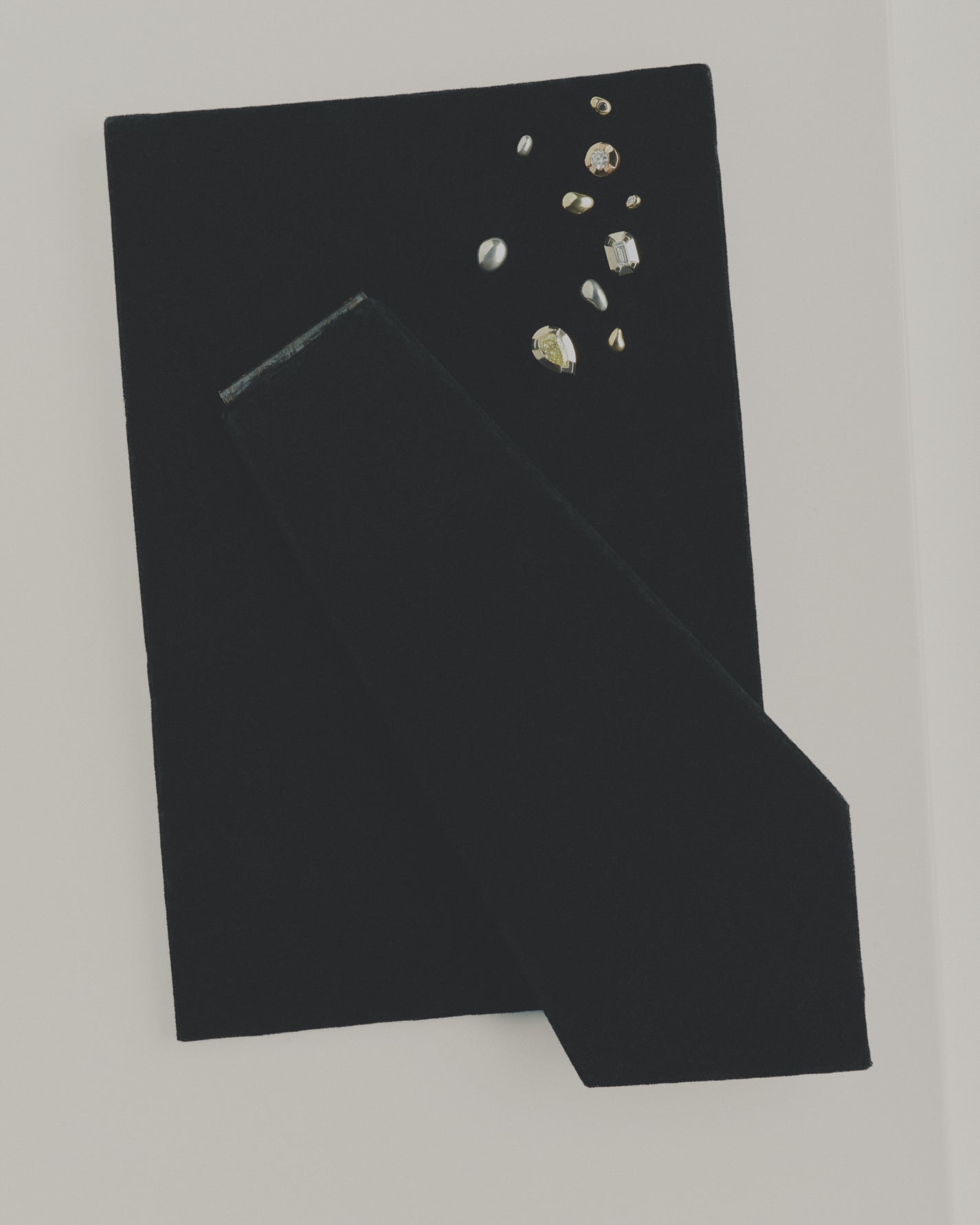 Black fabric with mixed stud earrings on a white background