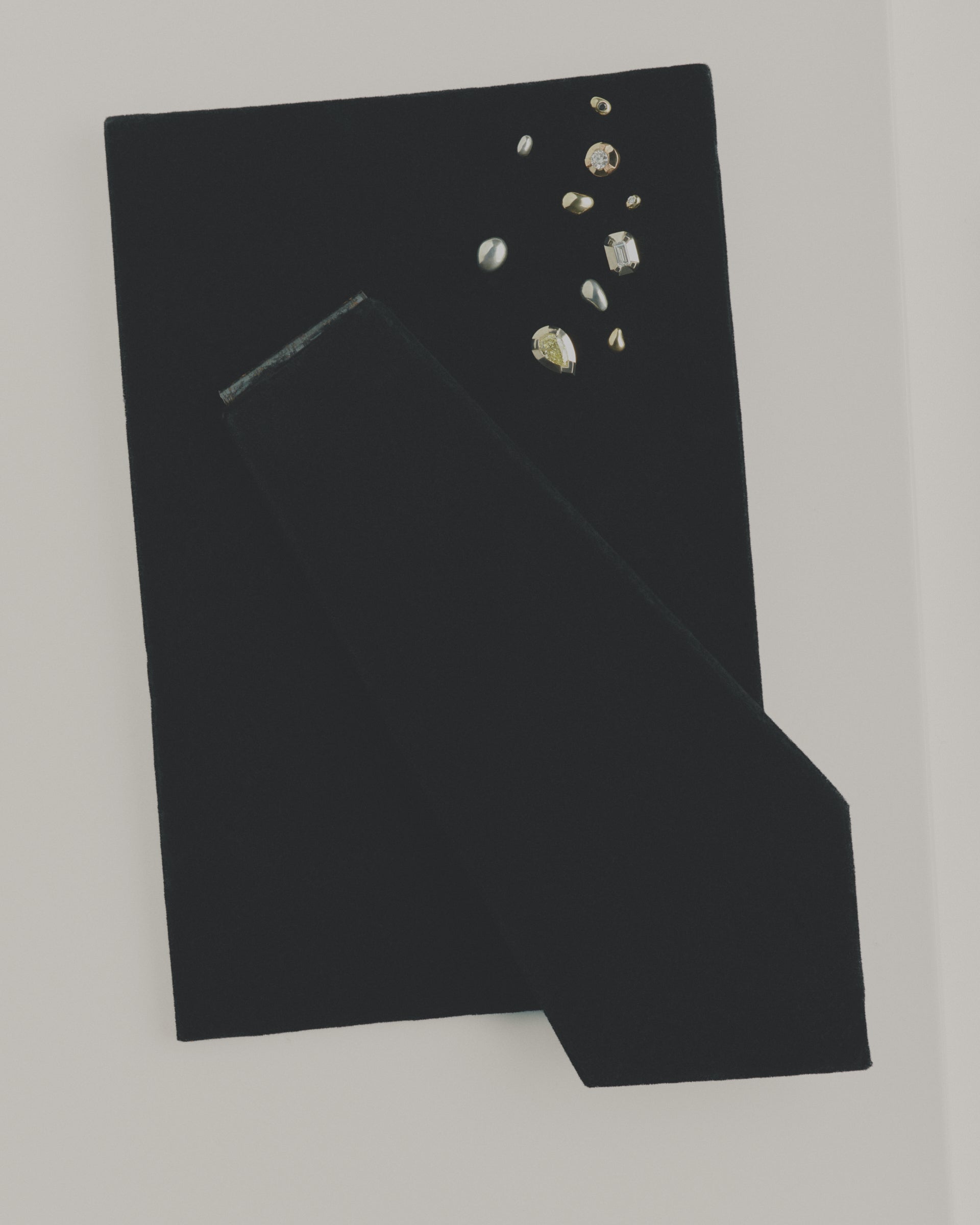 Black fabric with mixed stud earrings on a white background