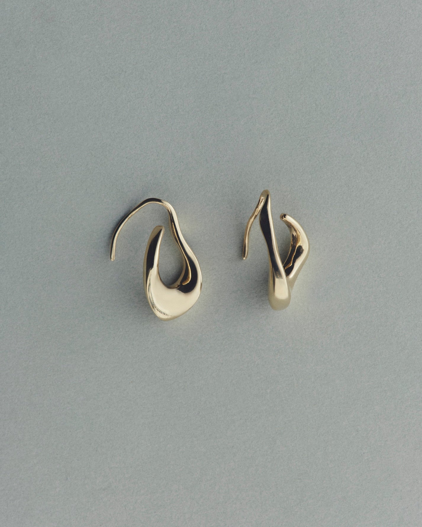 Pair of gold earrings on a gray background