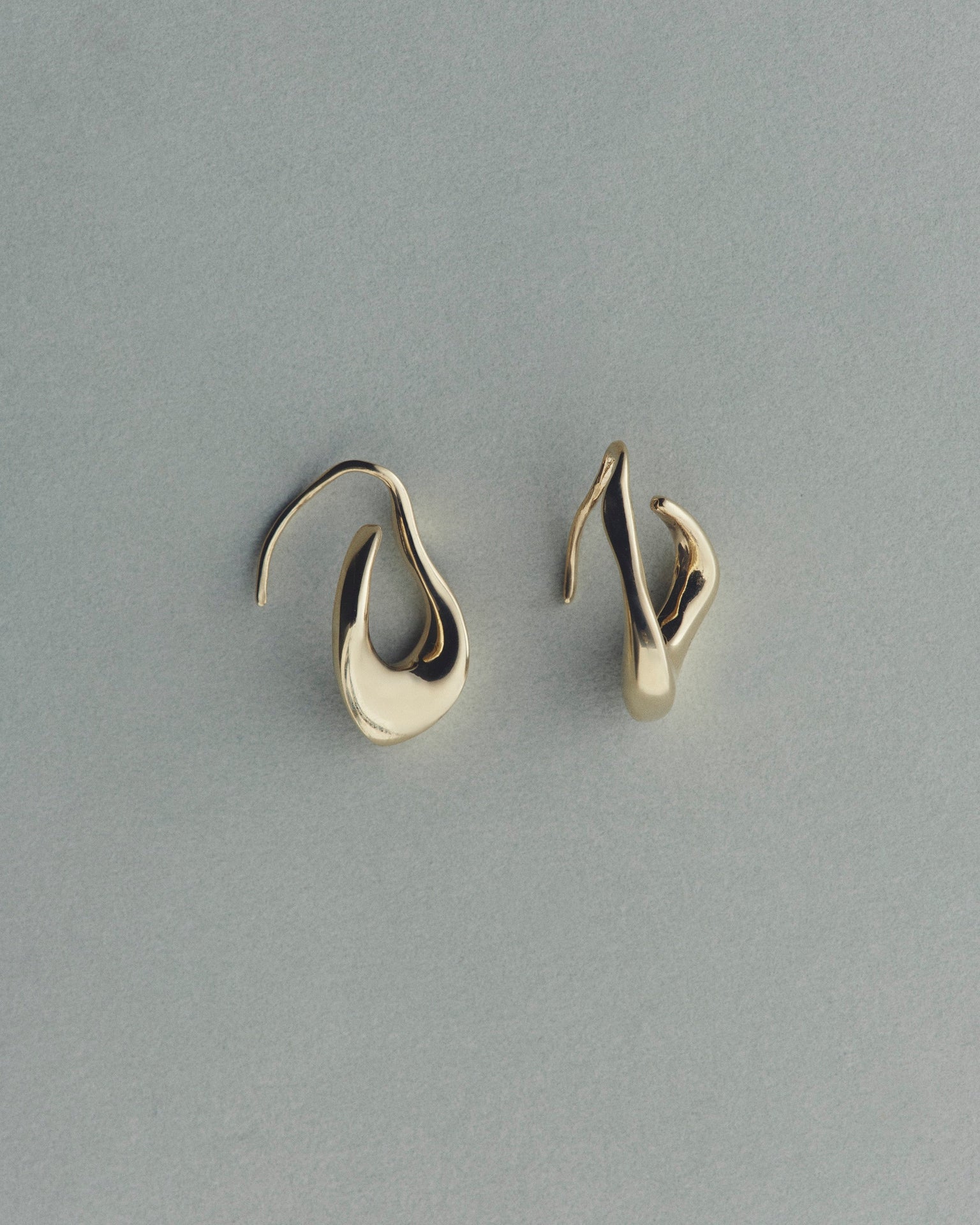 Pair of gold earrings on a gray background