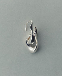 Silver earring on a gray background