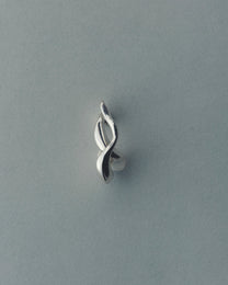 Silver earring on a gray background