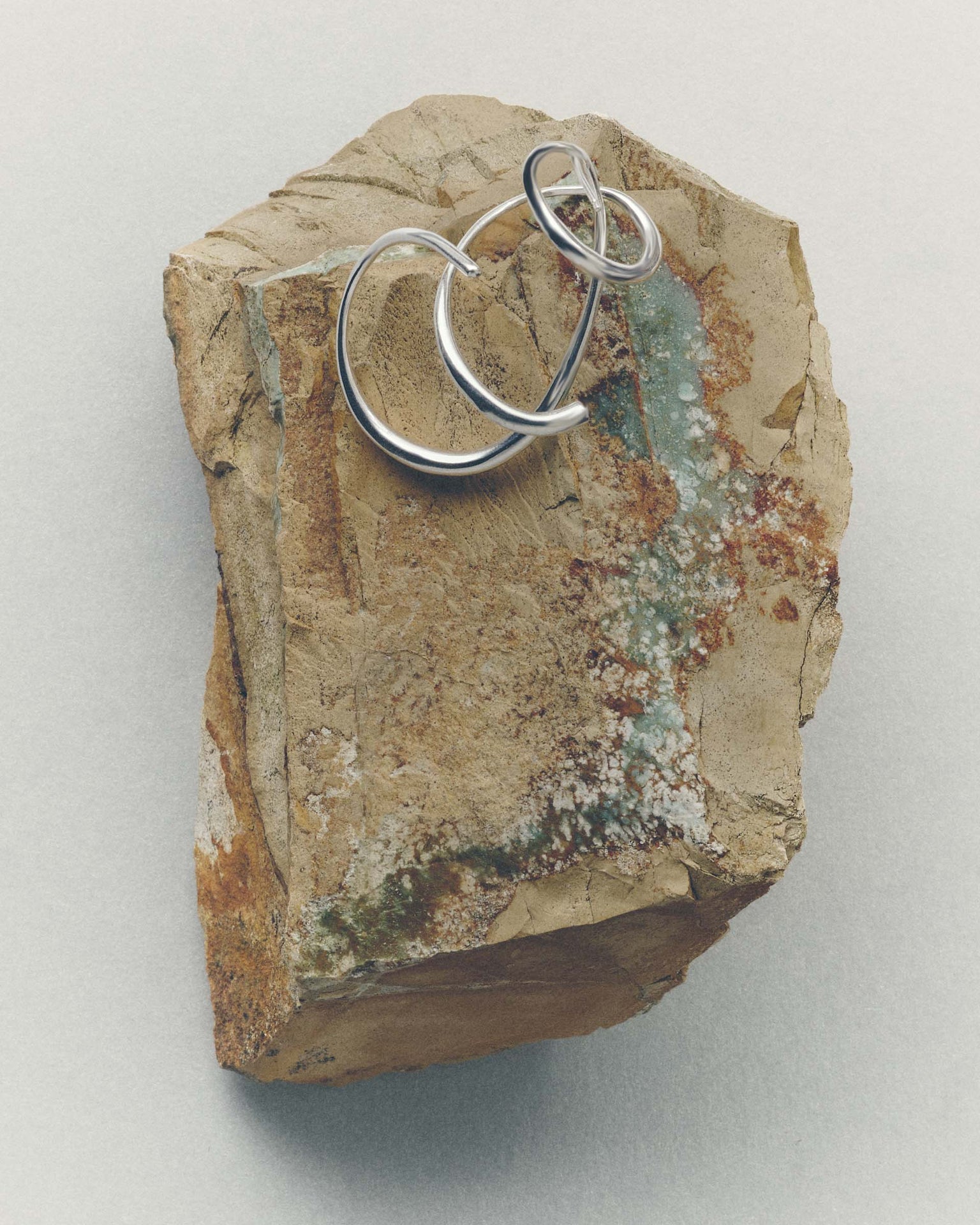 Silver ring on a textured stone surface