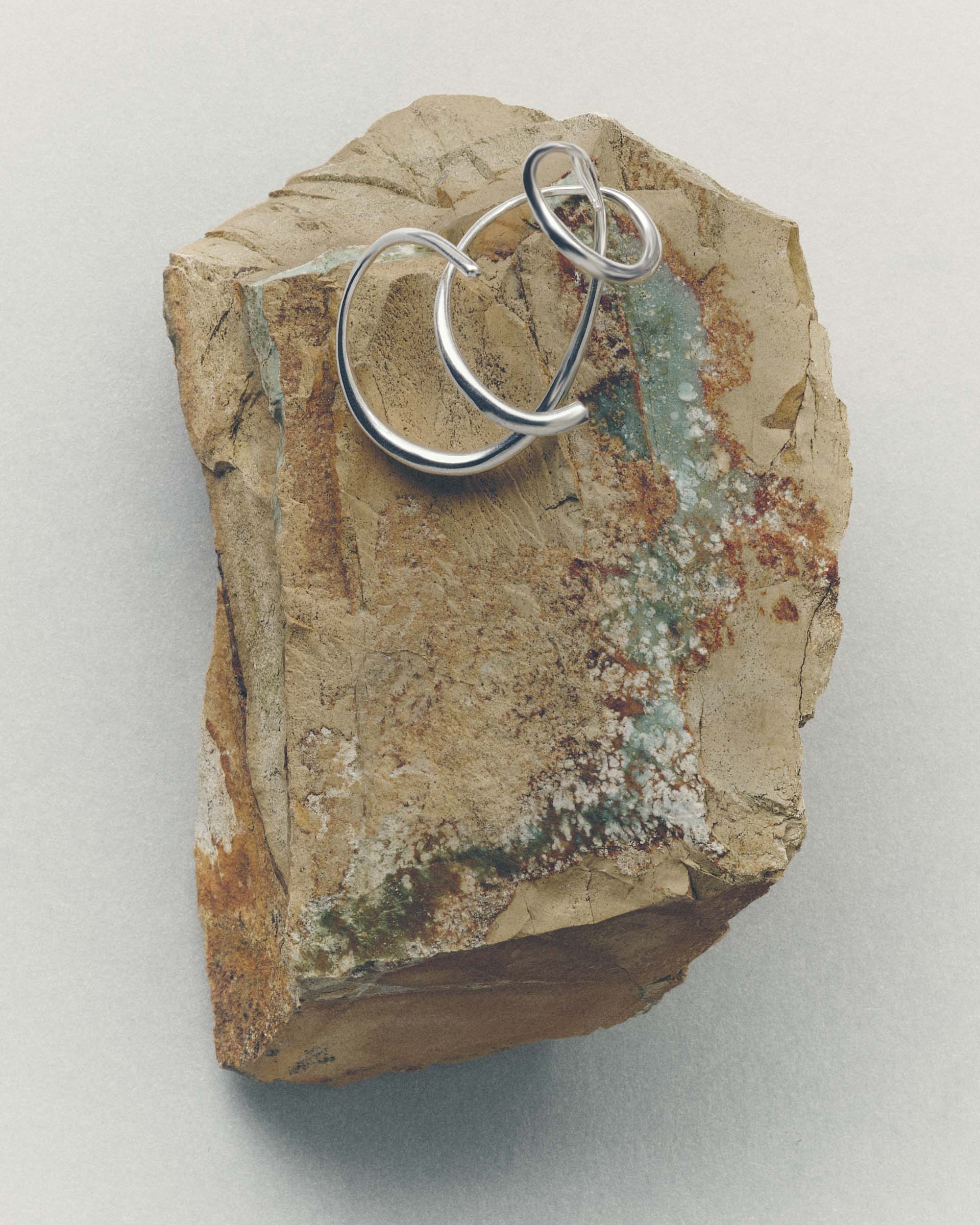 Silver ring on a textured stone surface