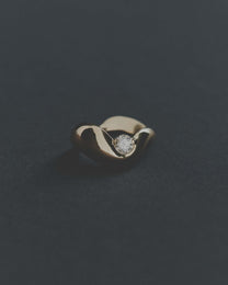Gold ring with a diamond on a dark gray background