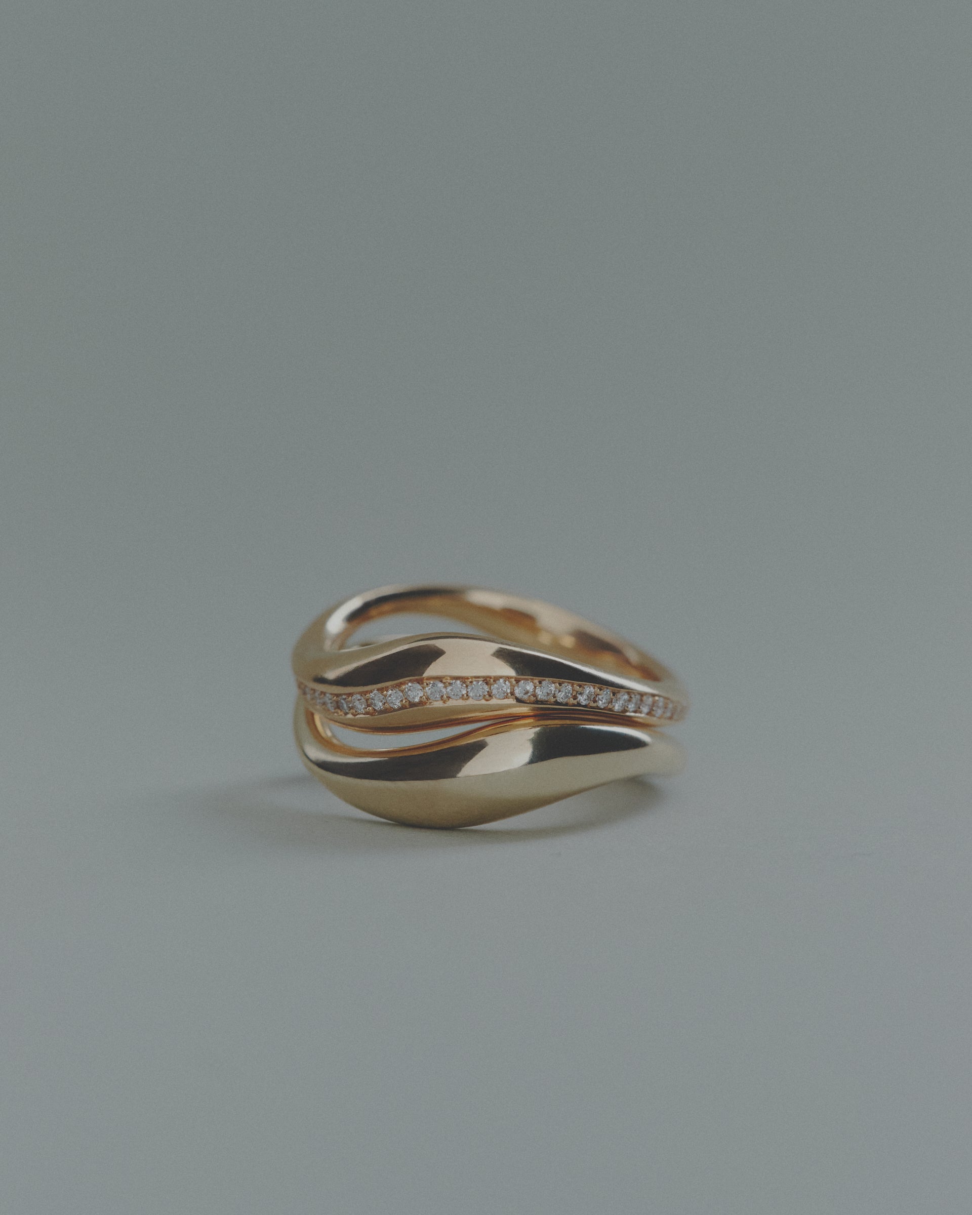 Two gold rings, one with small diamonds, on a gray background