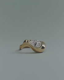 Gold ring with a pear diamond on a gray background