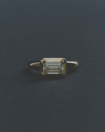 Gold ring with a rectangular diamond on a dark gray background