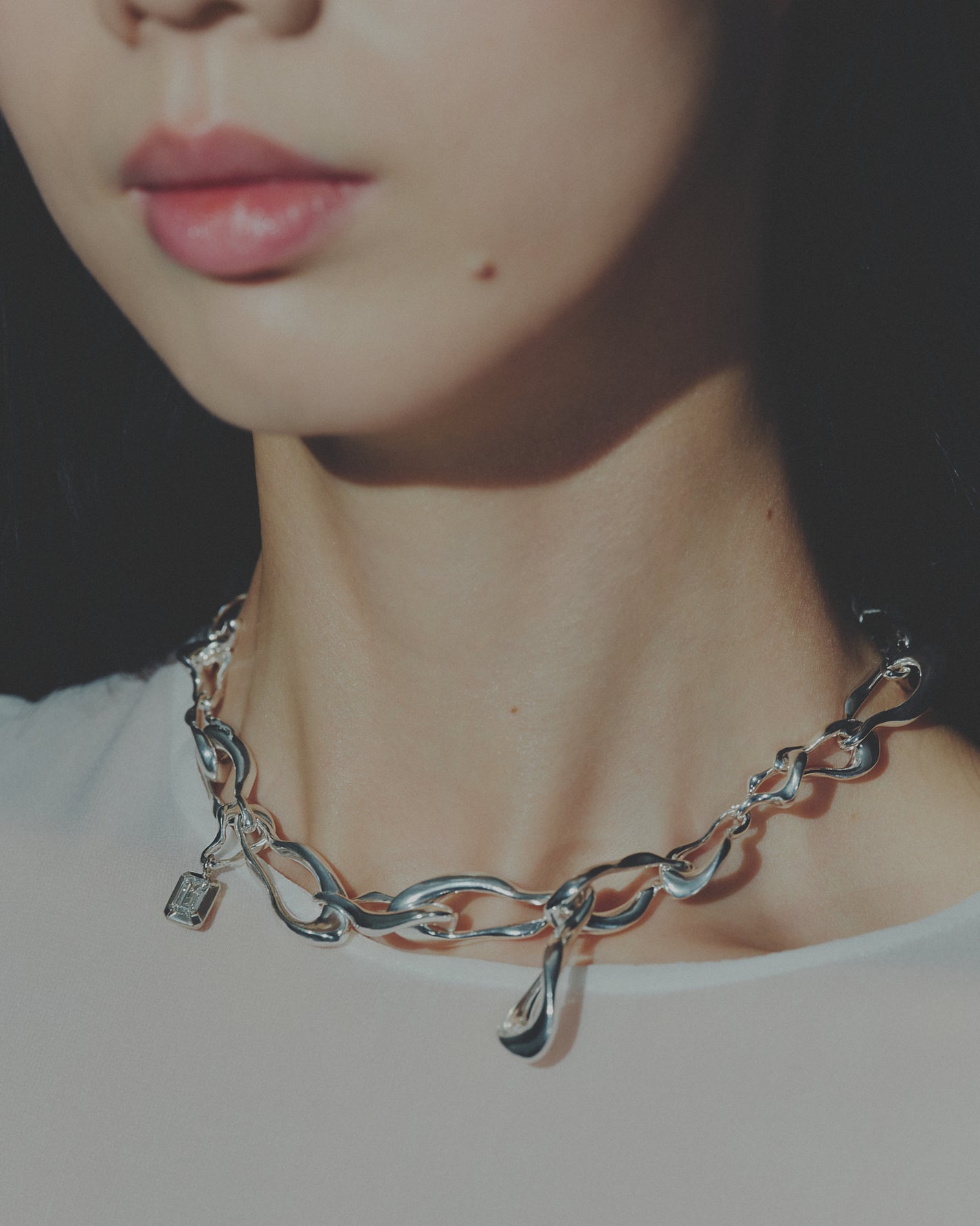 Close-up of a silver chain necklace worn by a person
