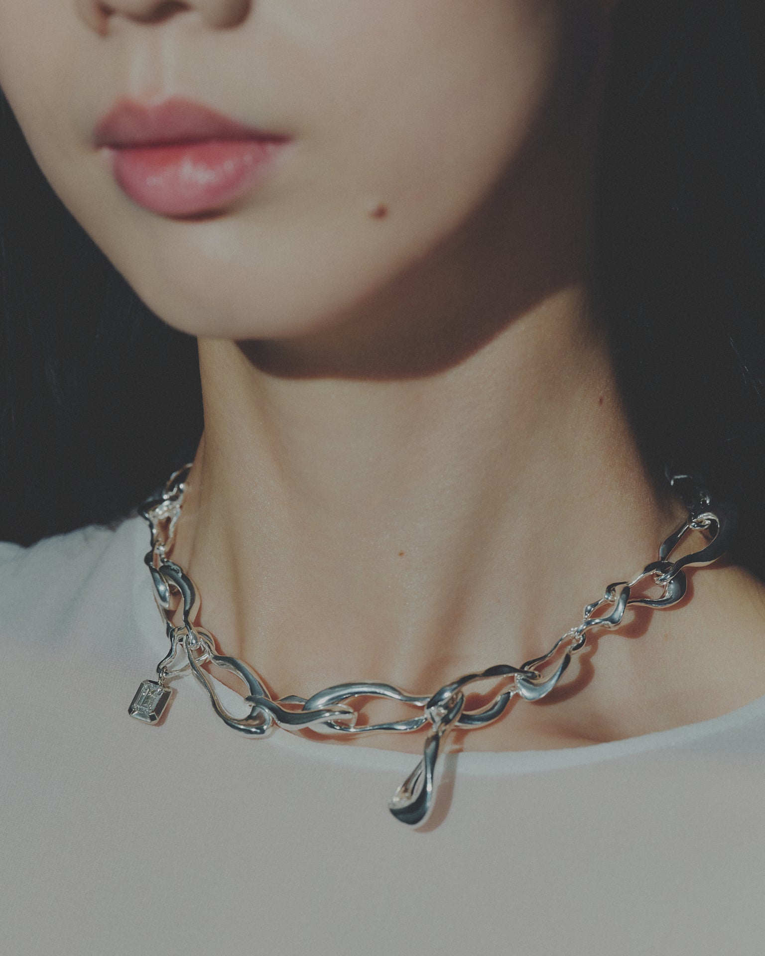 Close-up of a silver chain necklace worn by a person