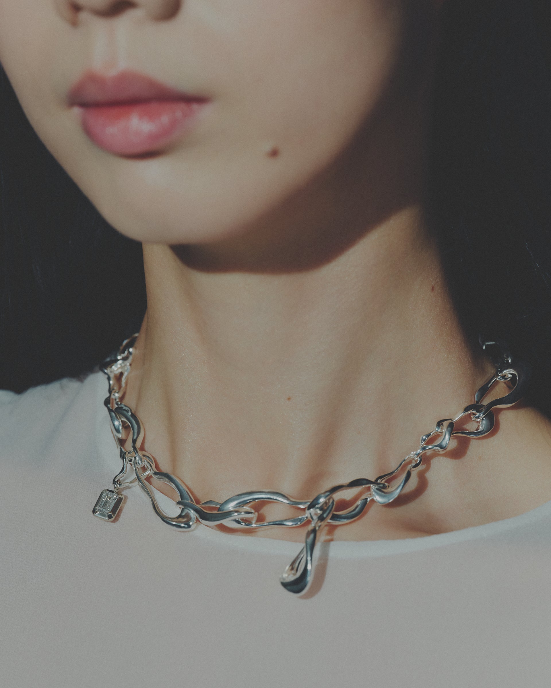 Close-up of a silver chain necklace worn by a person