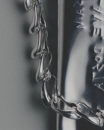 Close-up of a silver chain necklace with a blurred background