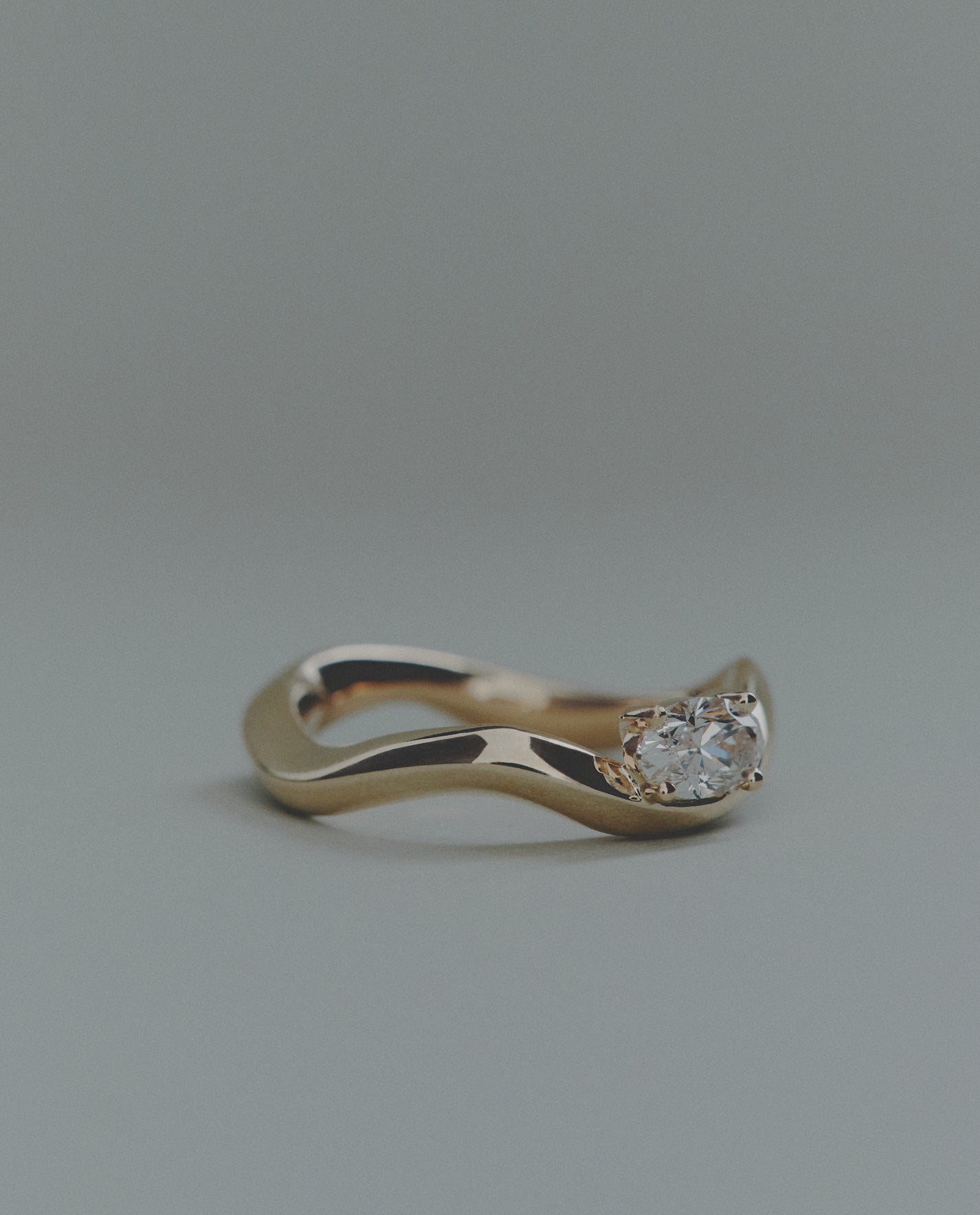 Gold ring with a diamond on a gray background