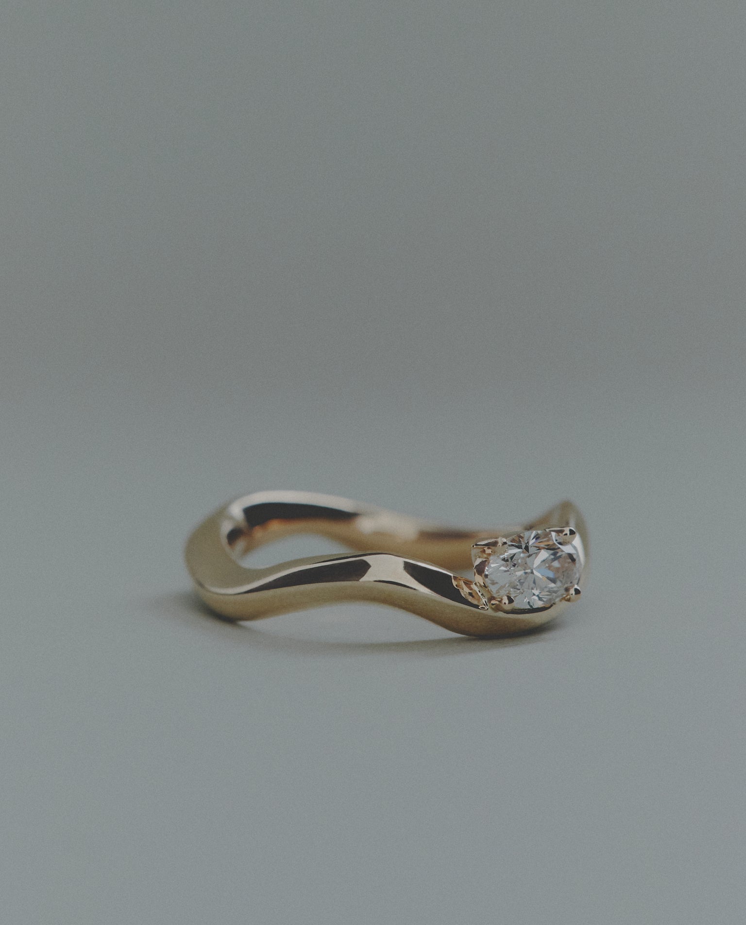 Gold ring with a diamond on a gray background