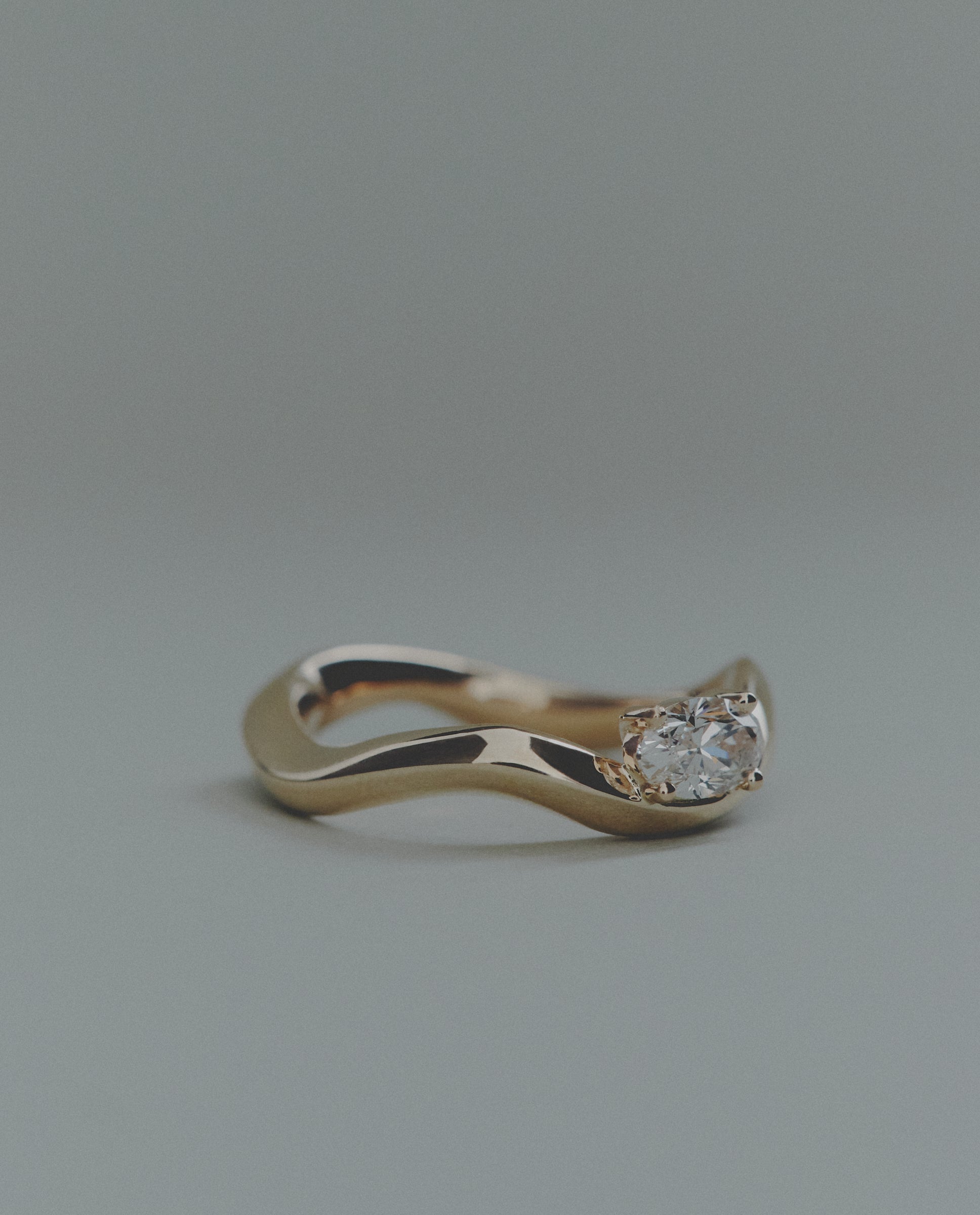 Gold ring with a diamond on a gray background