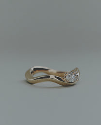 Gold ring with a diamond on a gray background