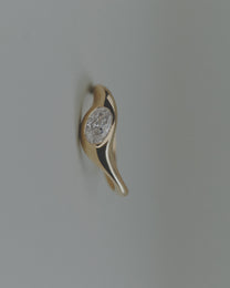Gold ring with an oval diamond on a light gray background