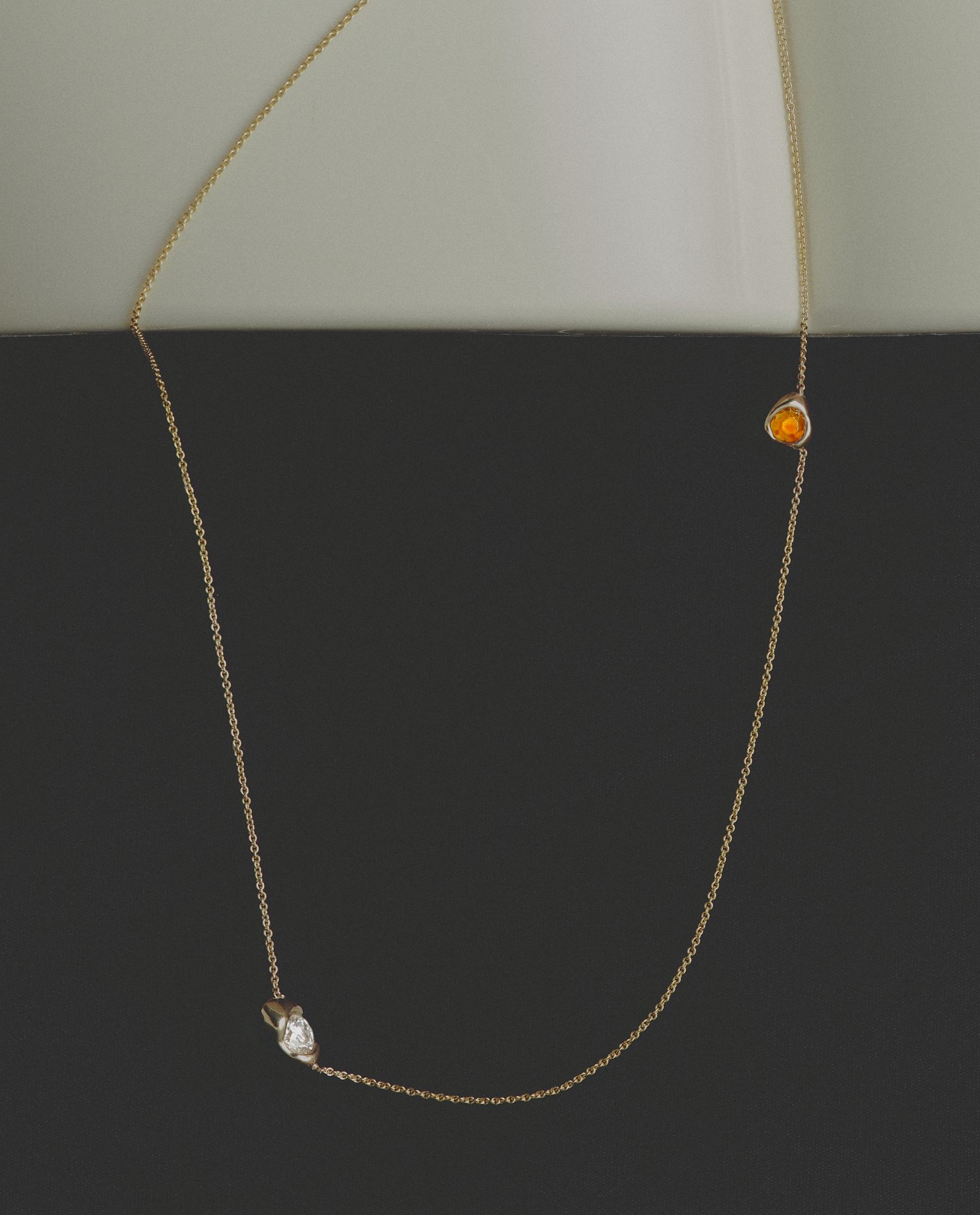 Necklace with two small gemstones on a plain background