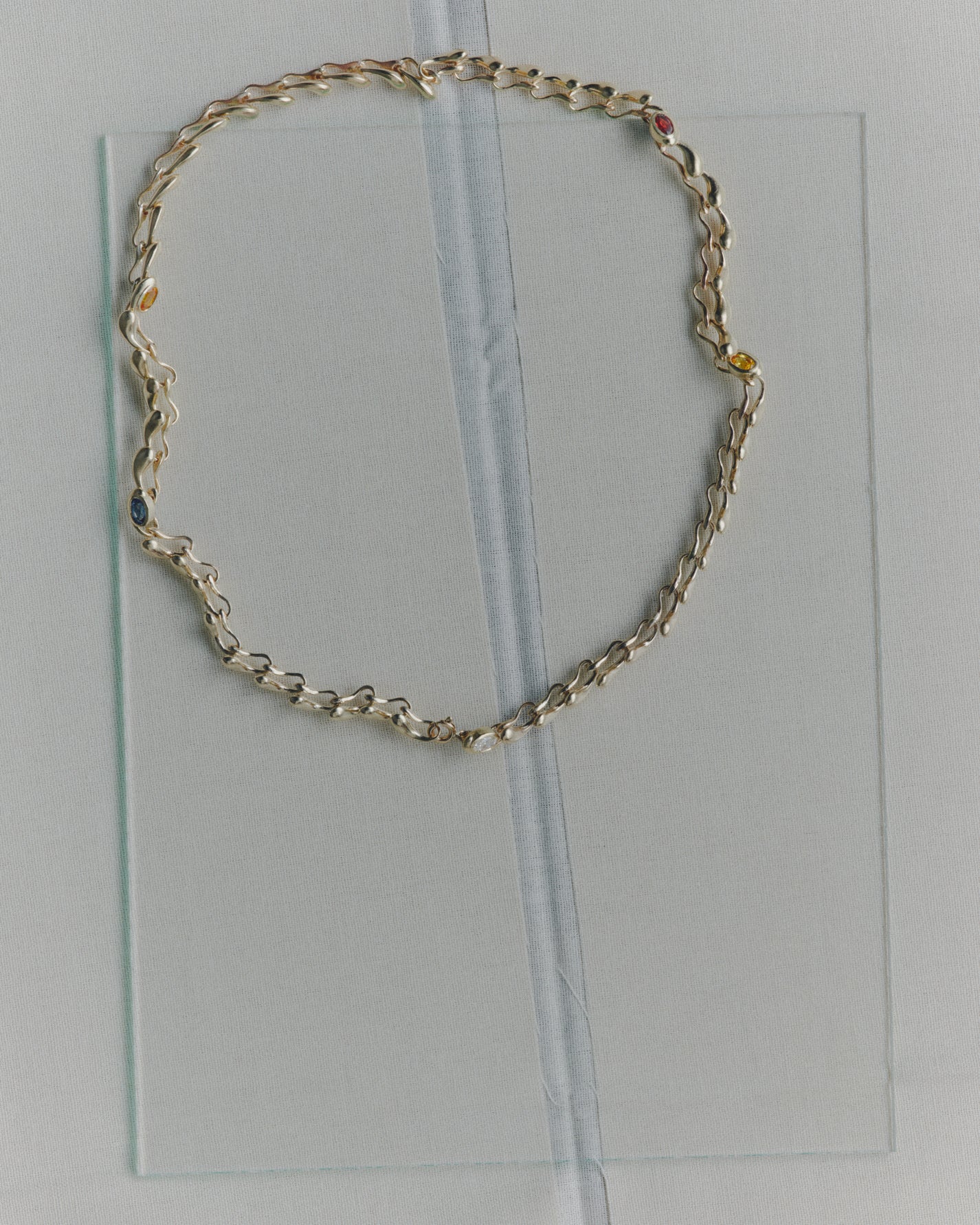 Gold chain necklace on a clear plastic sheet