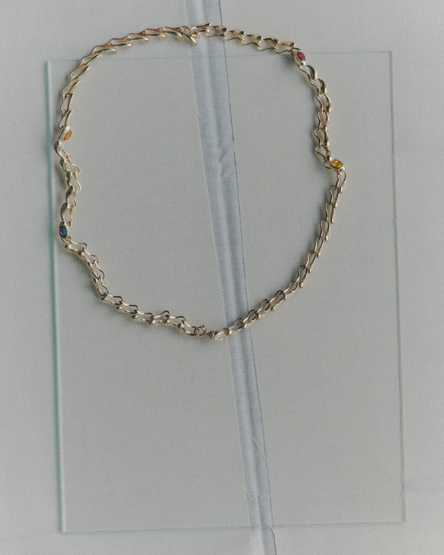 Gold chain necklace on a clear plastic sheet
