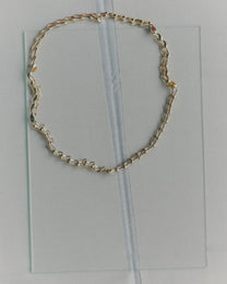 Gold chain necklace on a clear plastic sheet